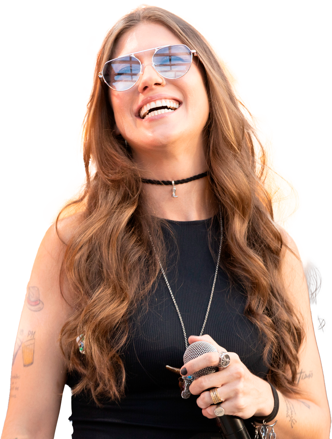Bruna Viola sorrindo, com óculos de sol e microfone na mão